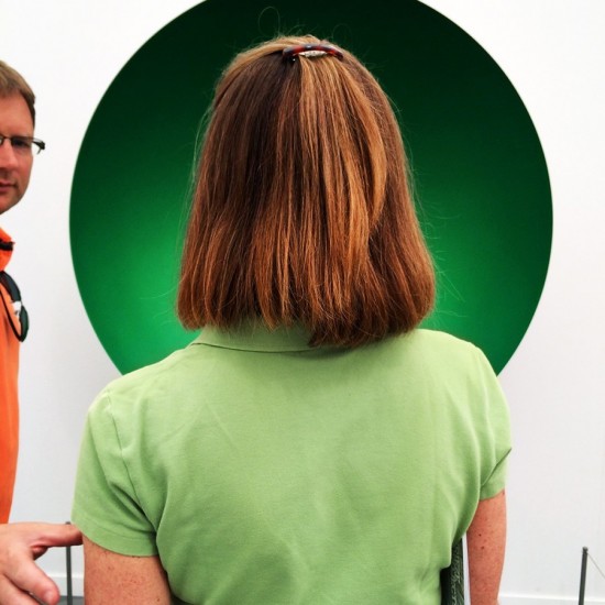Woman wearing green shirt in front of an Anish Kapoor Artwork 